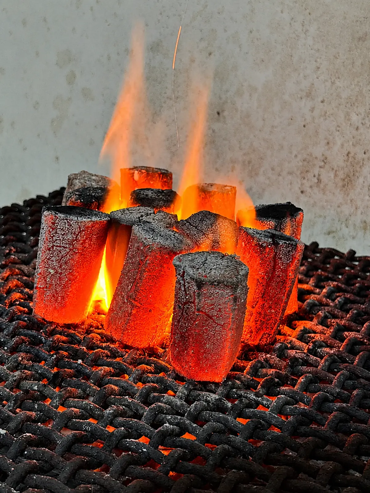 Burning hexagonal coconut charcoal briquettes for shisha